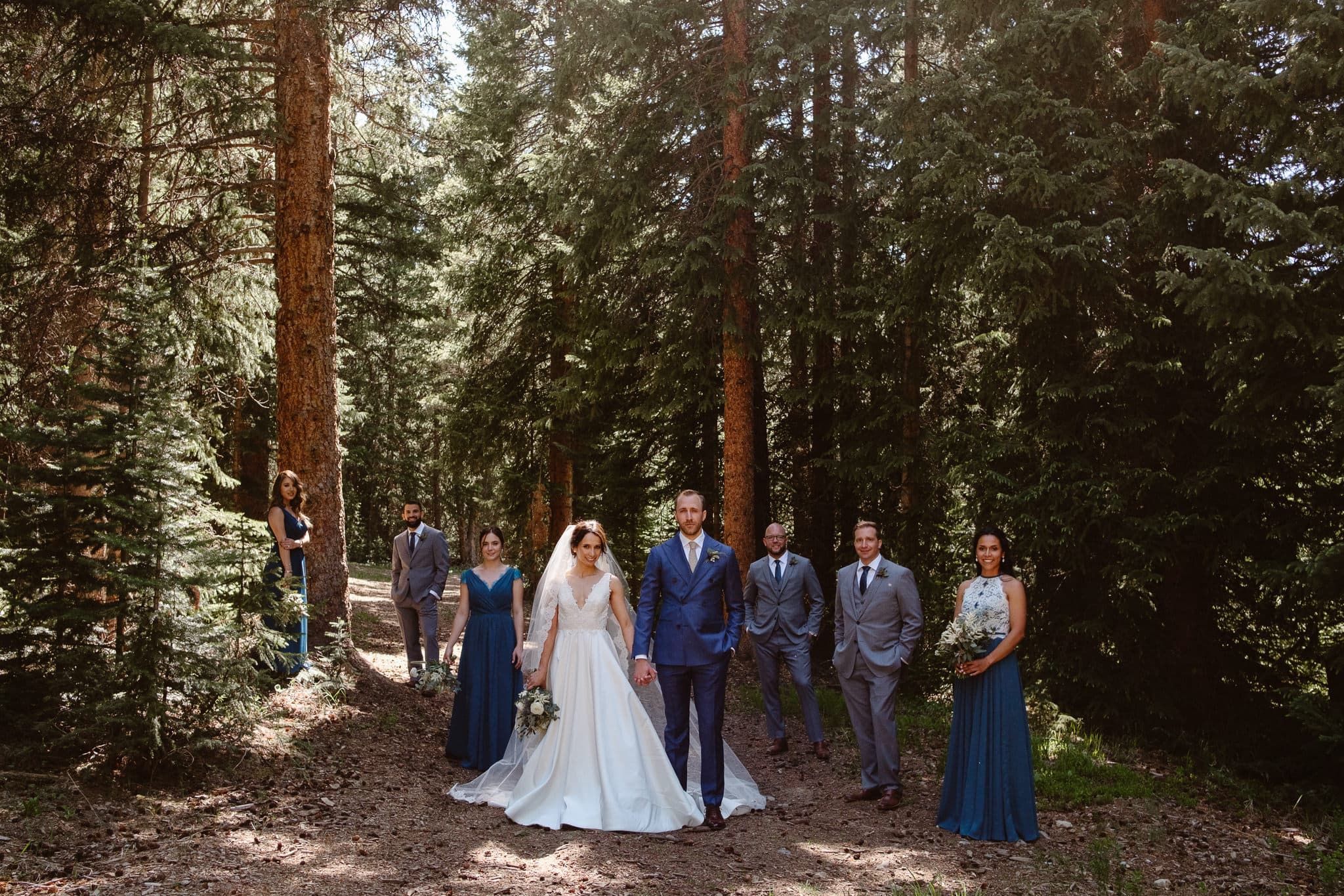 Bride and groom with their wedding party in the woods, Breckenridge Nordic Center wedding, Summit County wedding photographer 