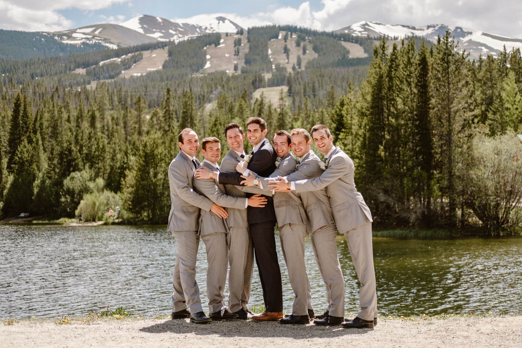 Groom in navy blue suit and groomsmen in light gray suits, wedding party photos, Breckenridge wedding photographer at Sawmill Reservoir