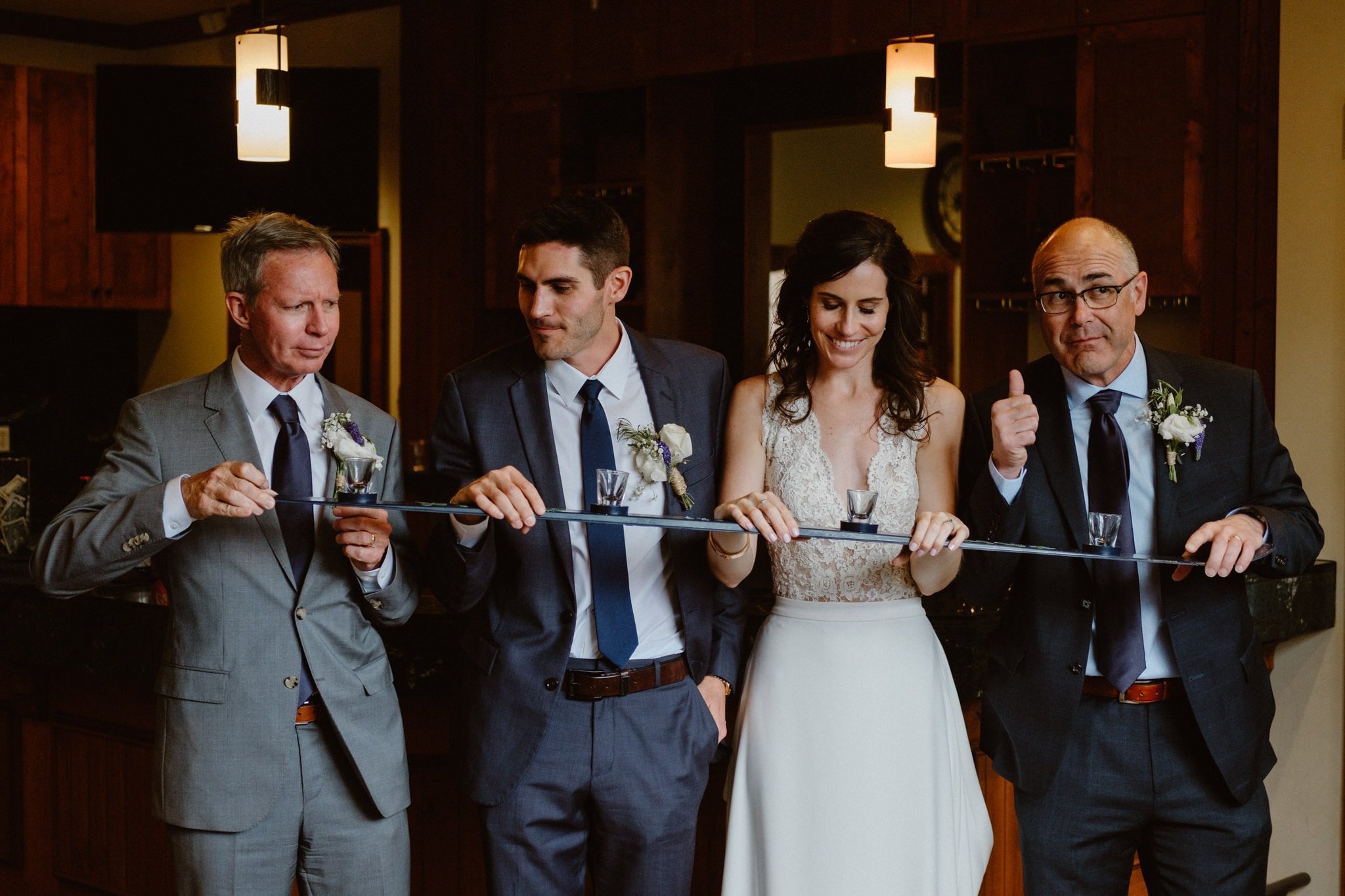 Bride and groom do shotski that says "Our adventure begins" with their dads at Breckenridge wedding, Colorado wedding photographer