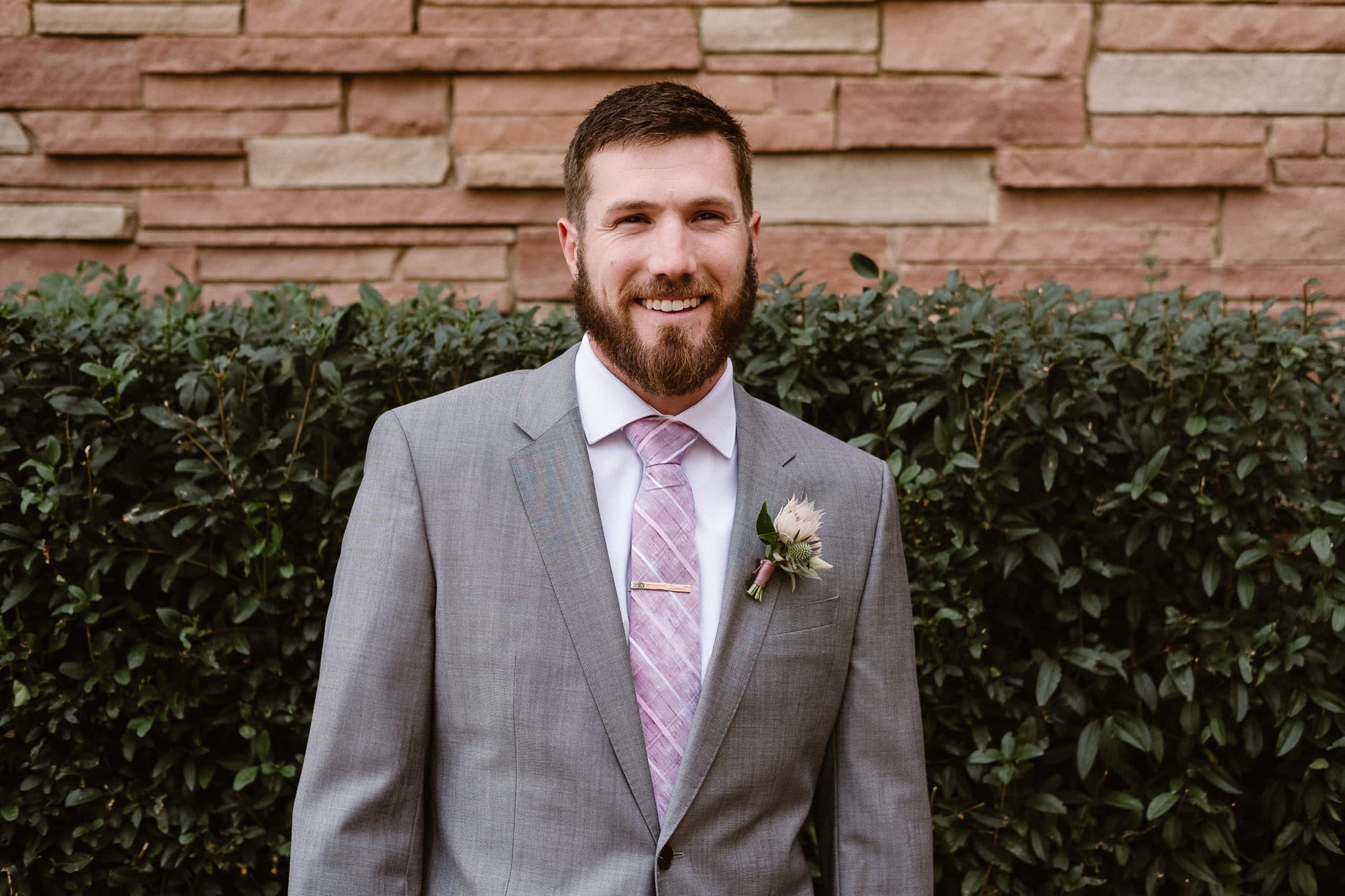 Groom getting ready for Colorado mountain elopement at St. Julien Hotel, Boulder wedding photographer, groom portrait, groom wearing gray suit and pale purple tie