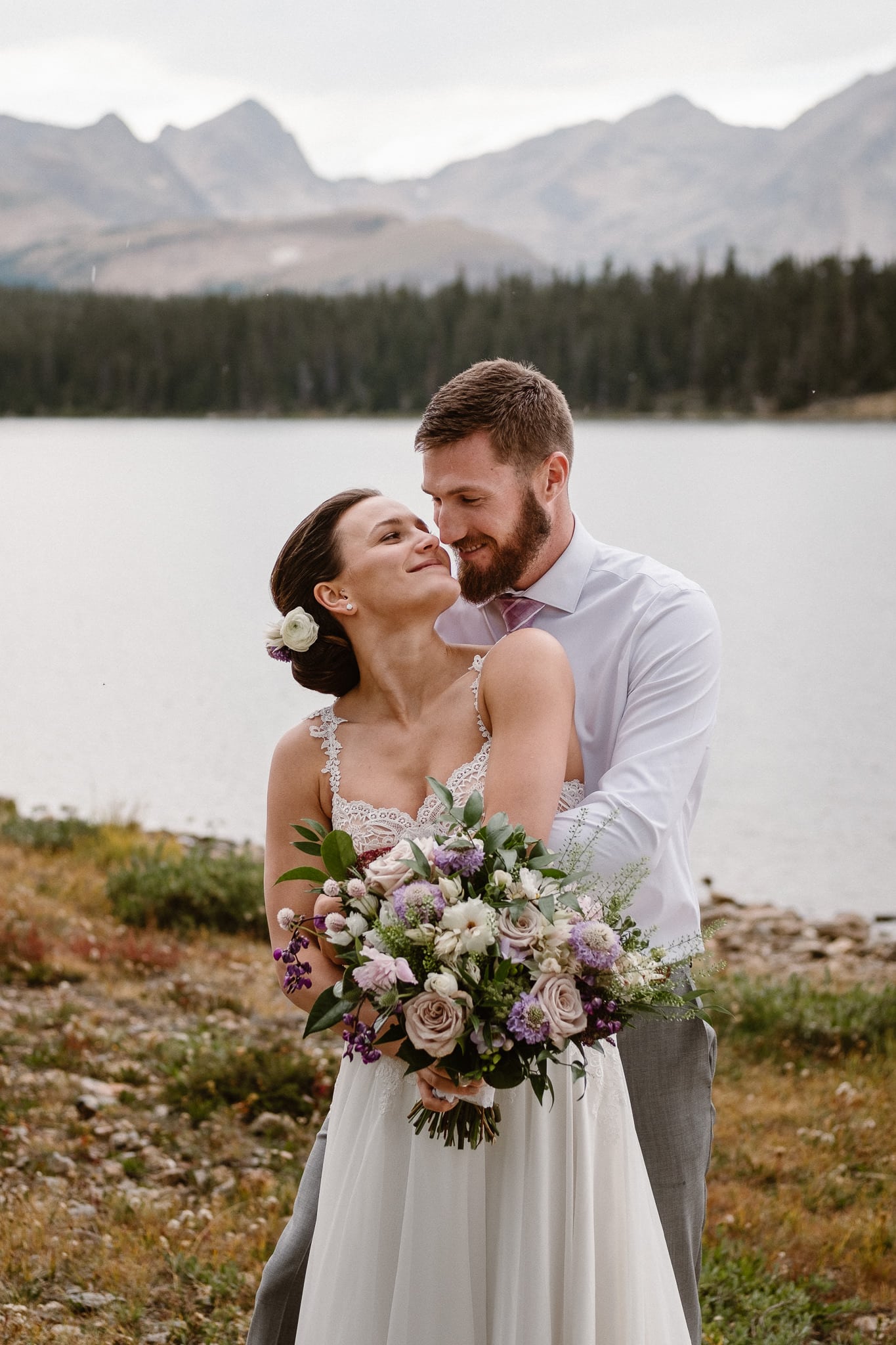 Colorado mountain elopement photographer, alpine lake adventure wedding, Boulder wedding photographer, bride and groom portraits in mountains, laidback boho wedding, hiking elopement, bouquet by Fawns Leap, pale pink and purple florals