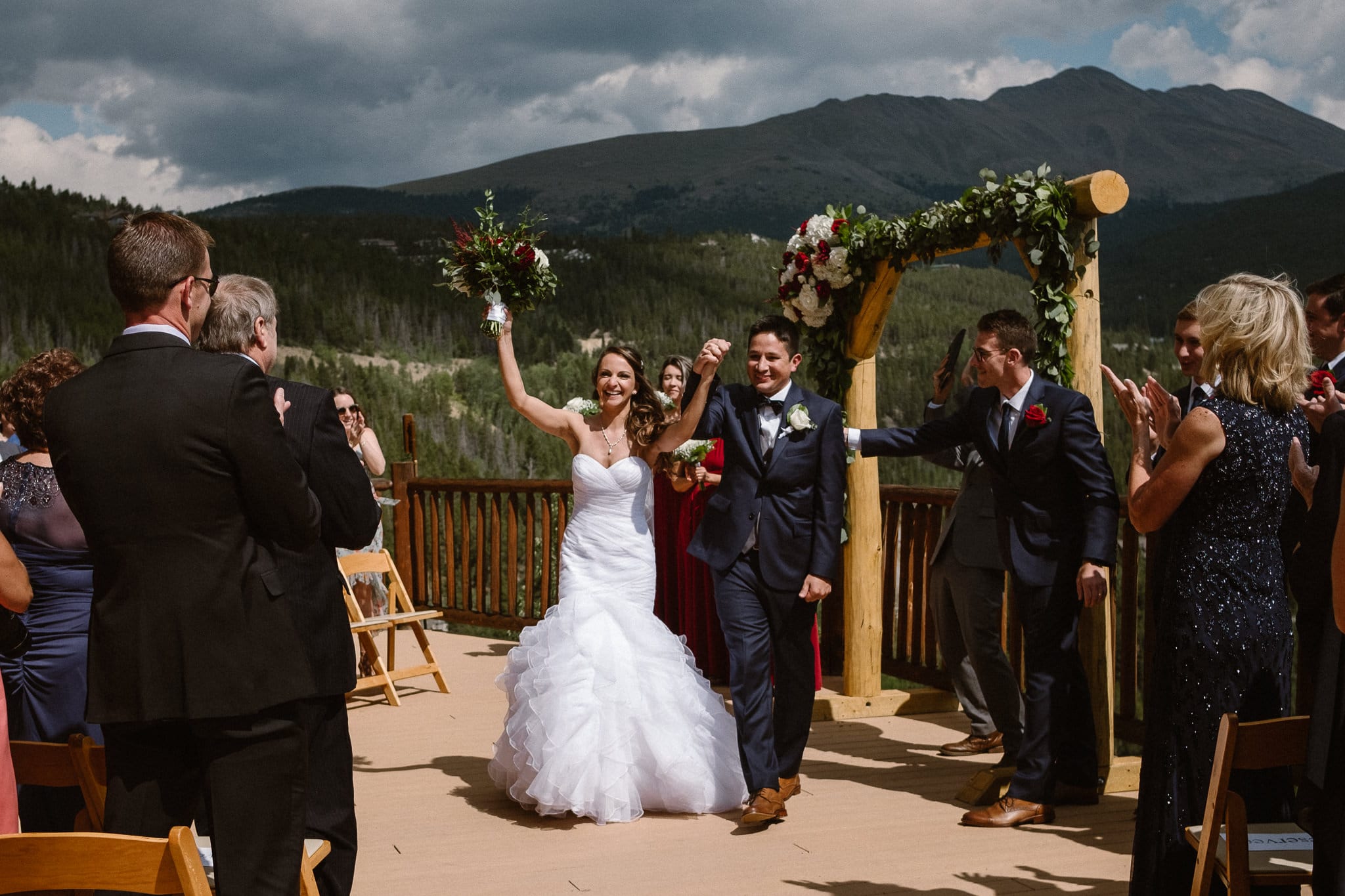 Lodge at Breckenridge Wedding Photographer, Colorado mountain wedding photographer, intimate wedding ceremony on deck with mountain views, bride and groom celebrating, recessional