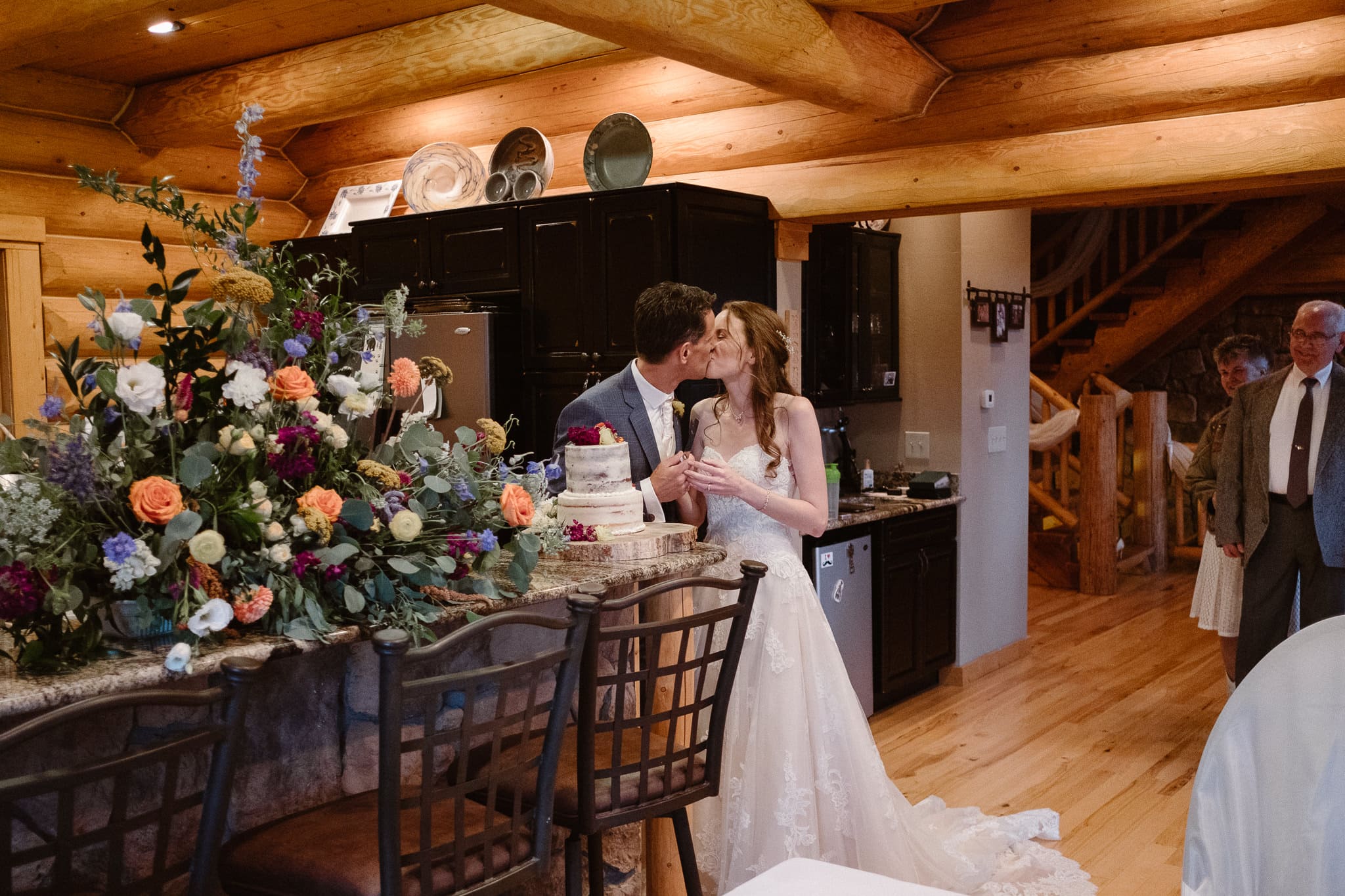 Red Feather Lakes elopement photographer, Colorado intimate cabin wedding, bride and groom cutting naked frosting wedding cake with flowers