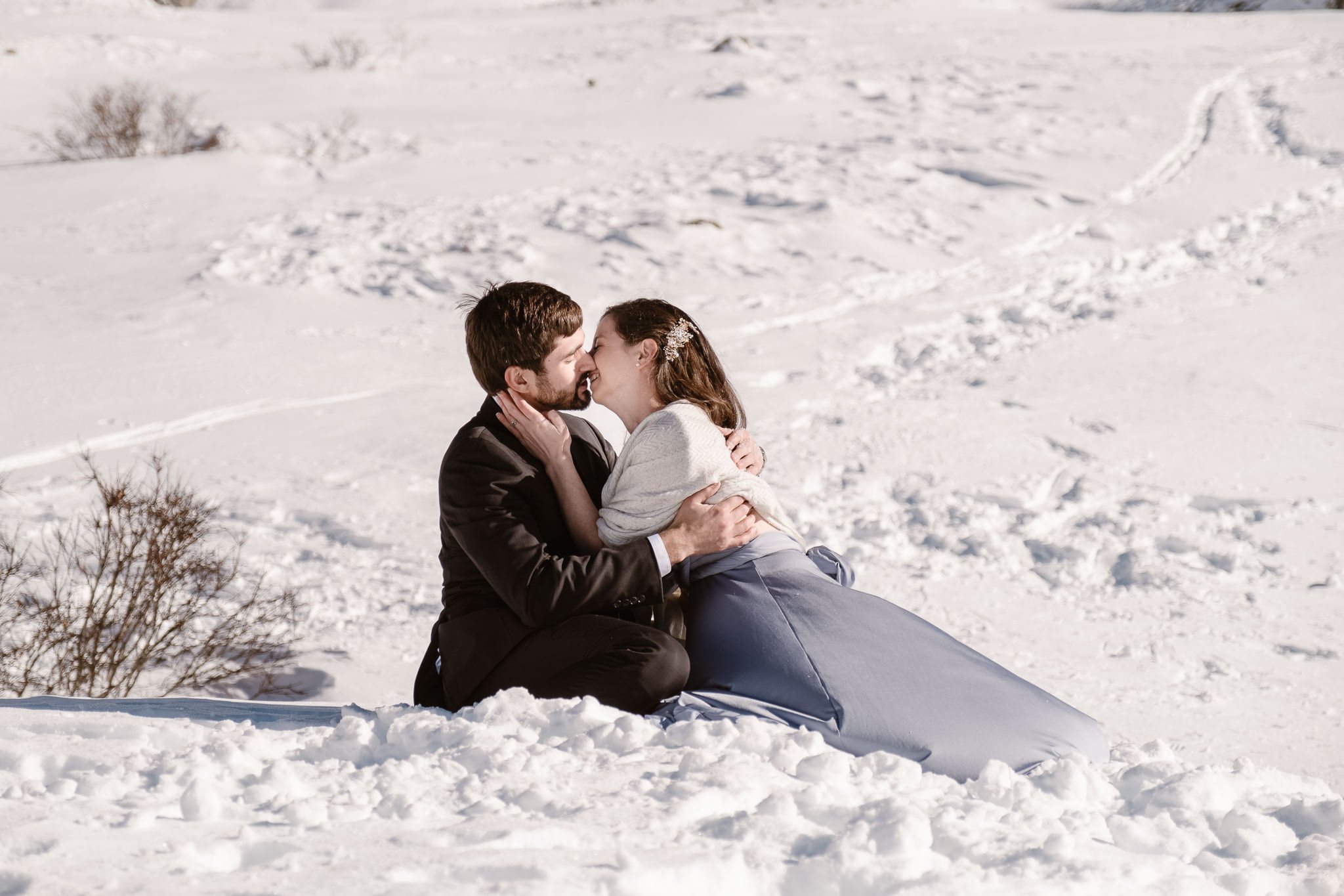 Bride and groom falling over in snow during first kiss, winter mountain elopement, Colorado snow elopement, winter wedding