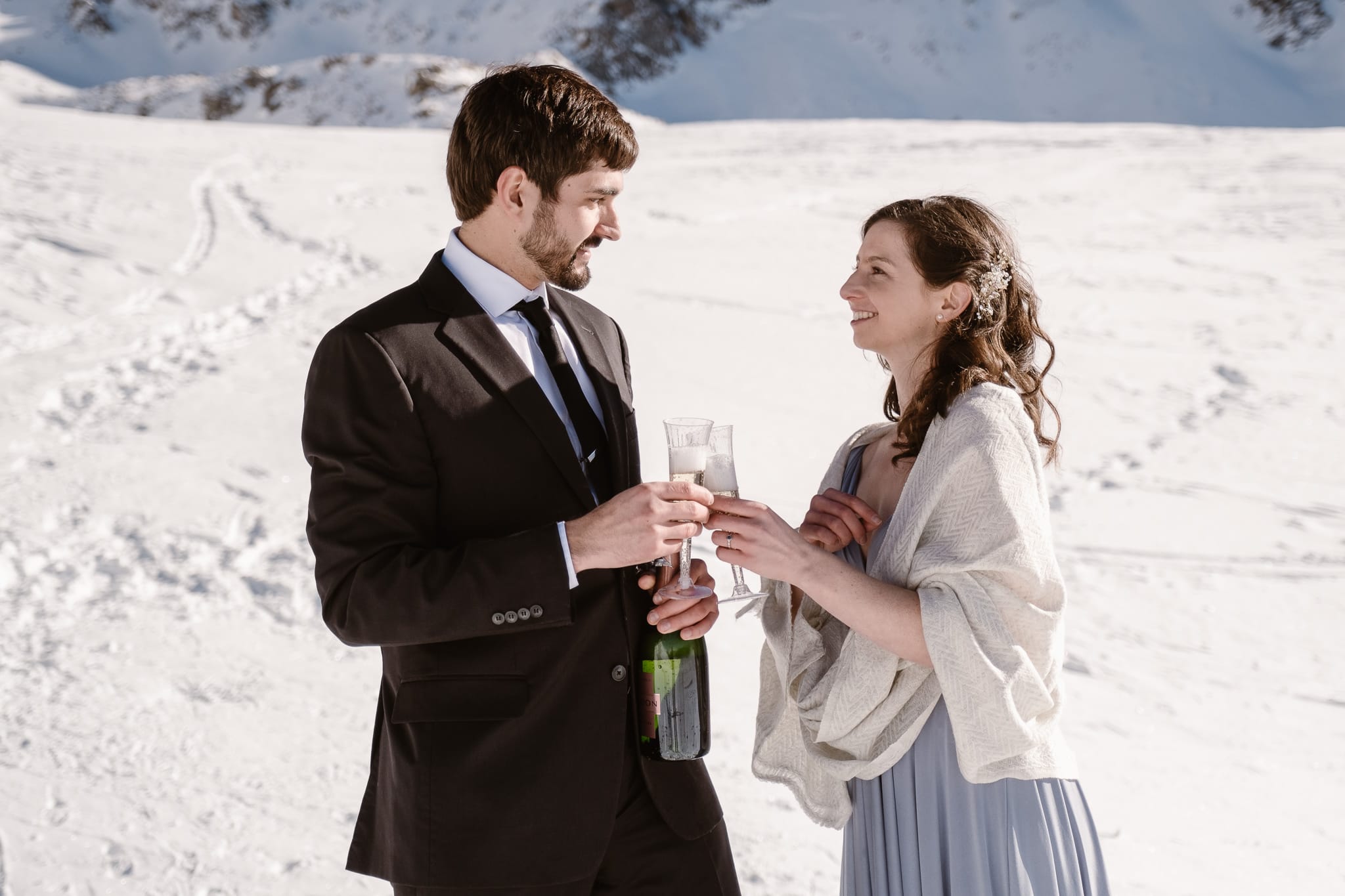 Bride and groom popping champagne bottle, winter mountain elopement, Colorado ski wedding, backcountry skiing elopement