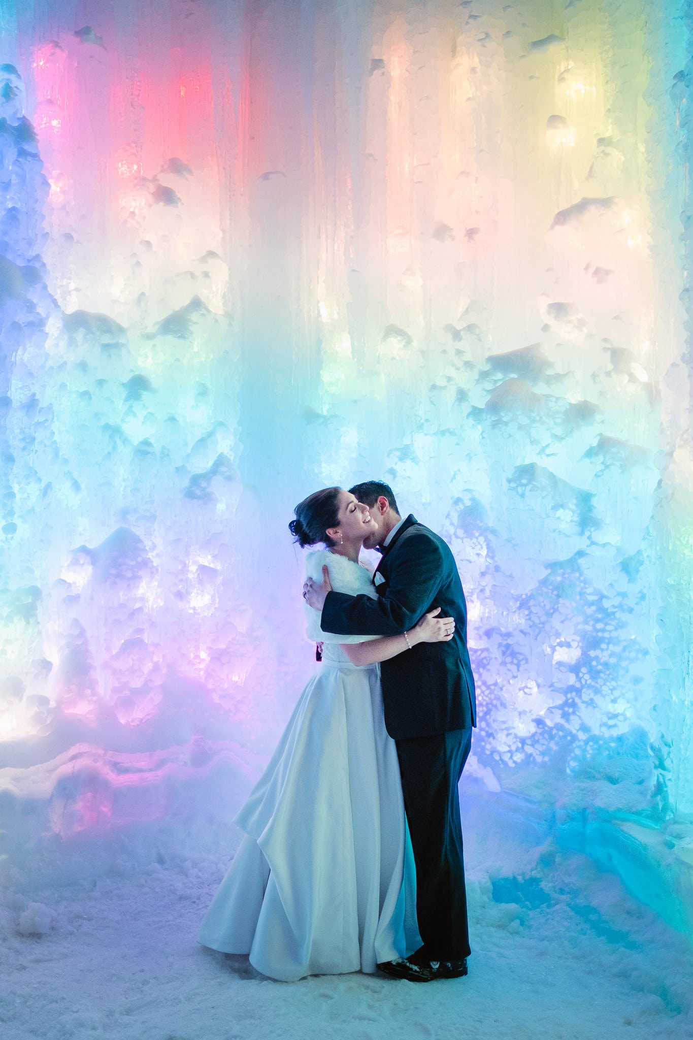 Ice Castles wedding photography, Dillon Colorado winter elopement, bride and groom inside ice castle lit up with rainbow lights