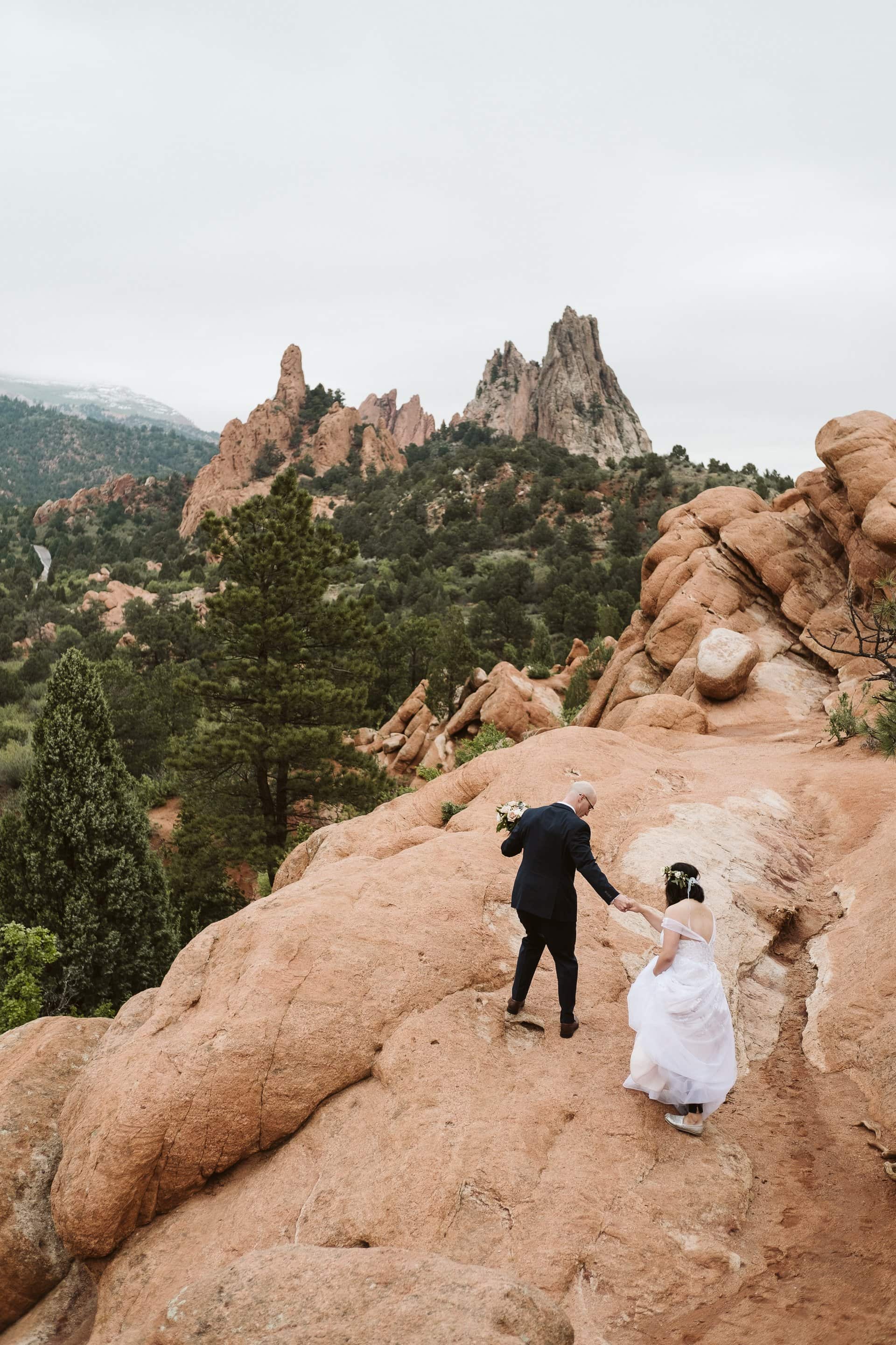 Bride and groom hiking at Garden of the Gods for their adventurous elopement in Colorado Springs