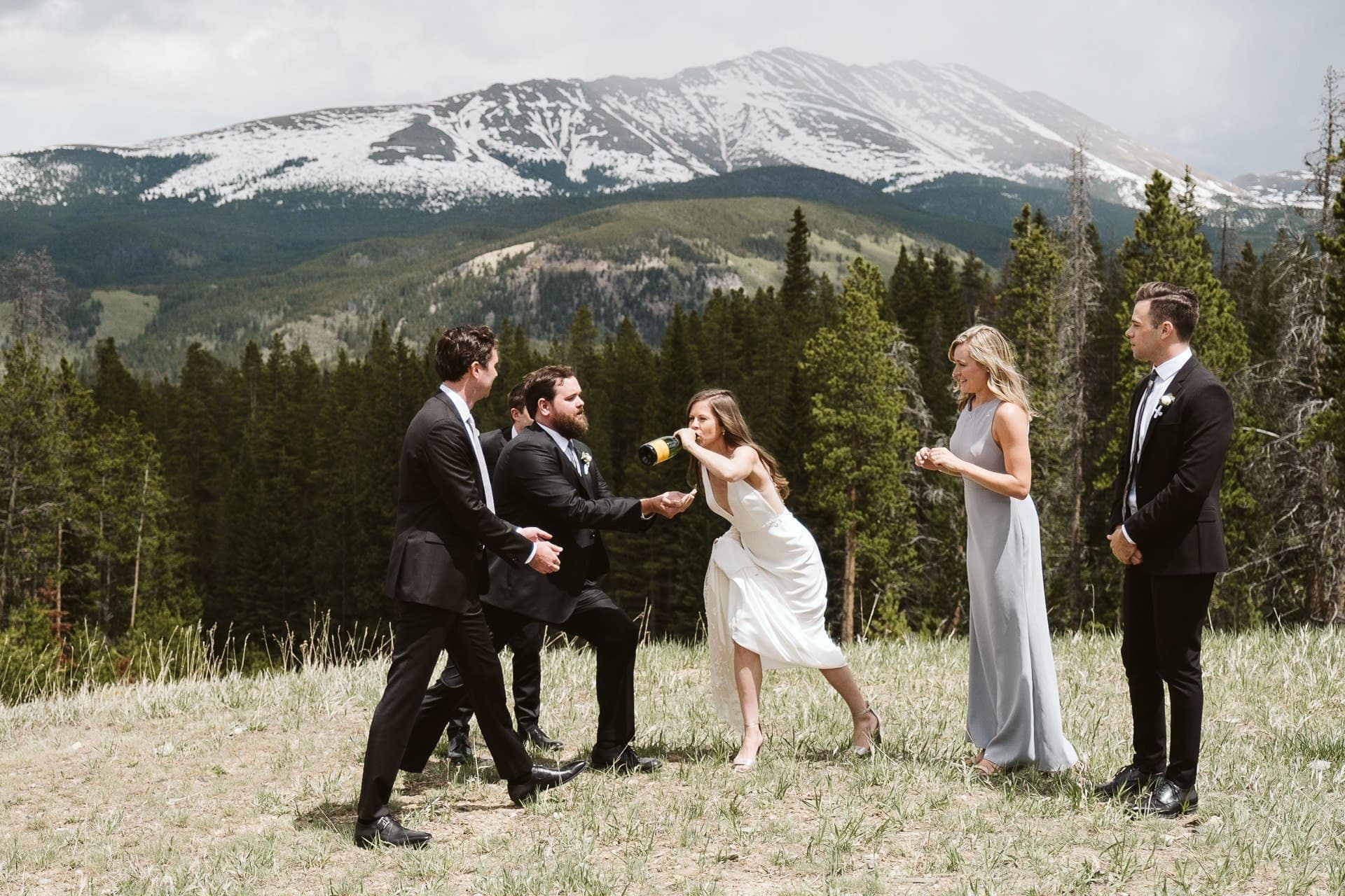 Bride and groom popping champagne with wedding party at Ten Mile Station, Breckenridge ski resort wedding, Colorado mountain wedding photographer