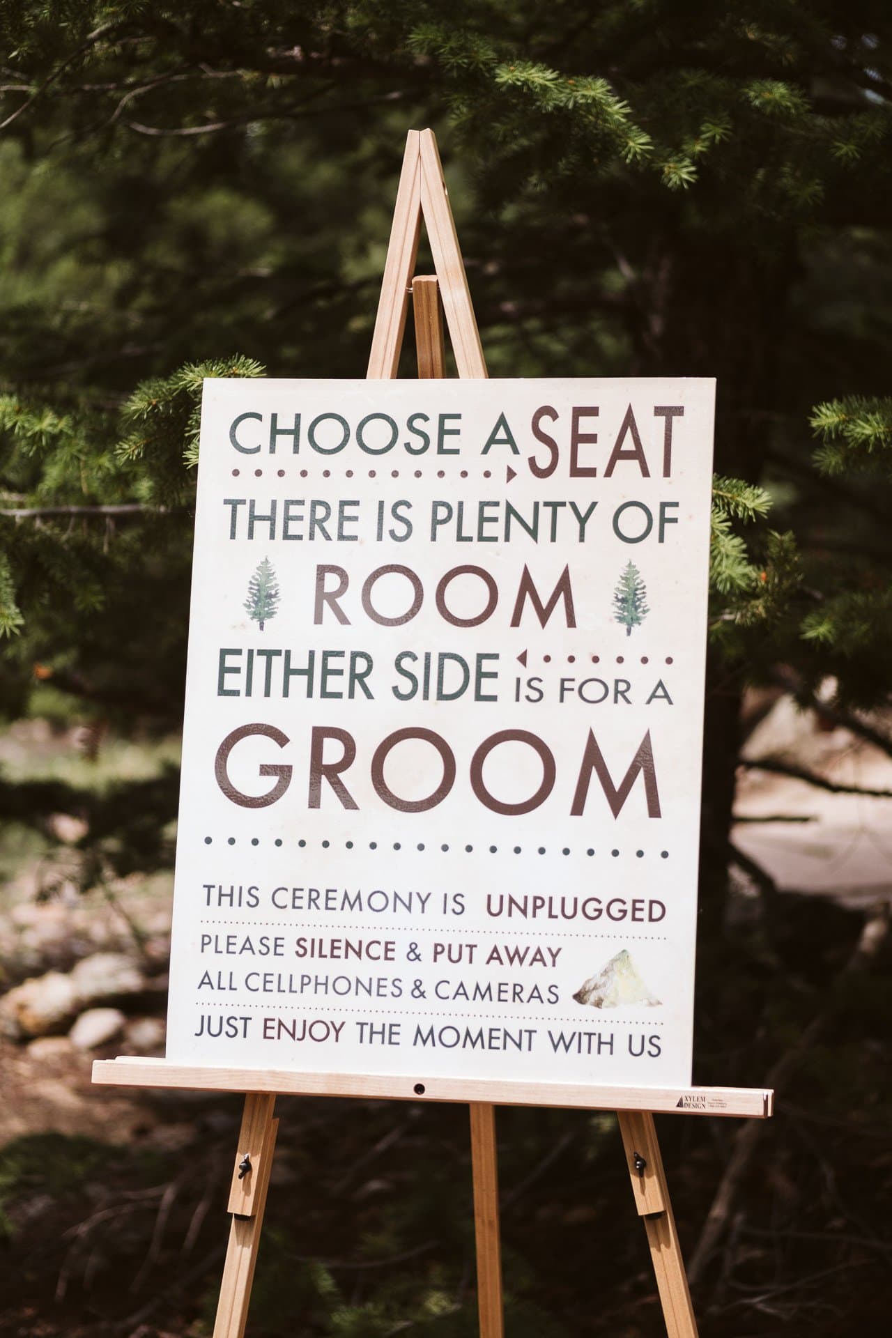 "Choose a seat there is plenty of room, either side is for a groom" ceremony sign at gay wedding