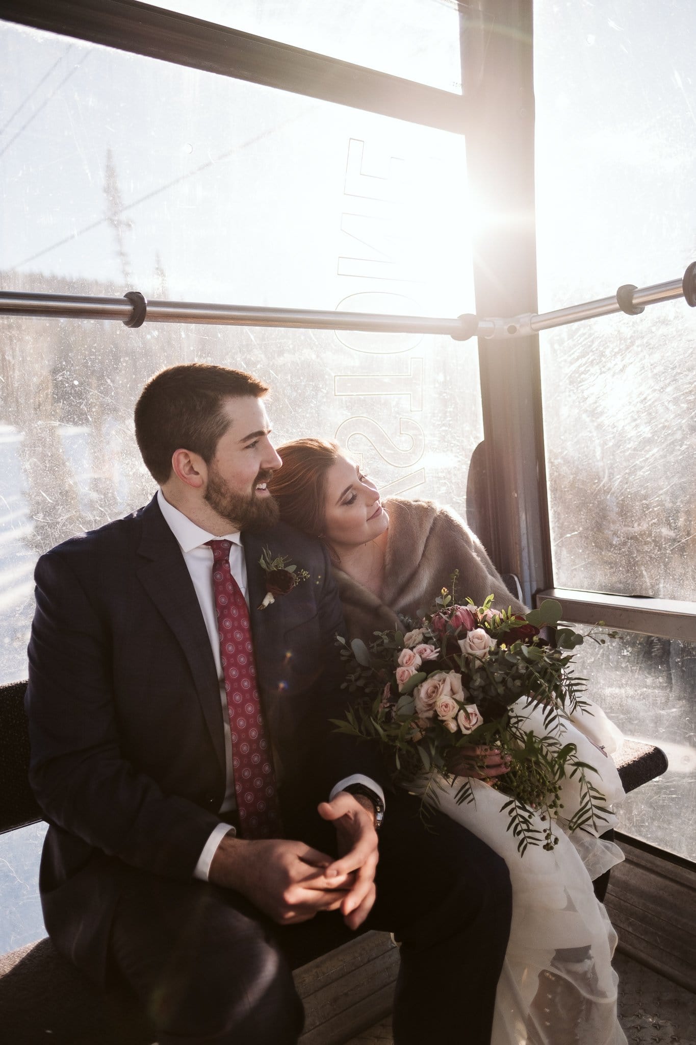 Bride and groom ride gondola at Keystone Ski Resort in Colorado for their winter wedding.