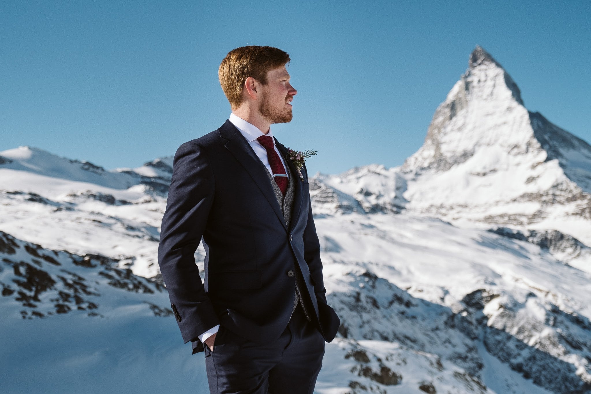 Groom wearing three-piece tweed suit in front of Matterhorn in Zermatt, Switzerland wedding photographer.