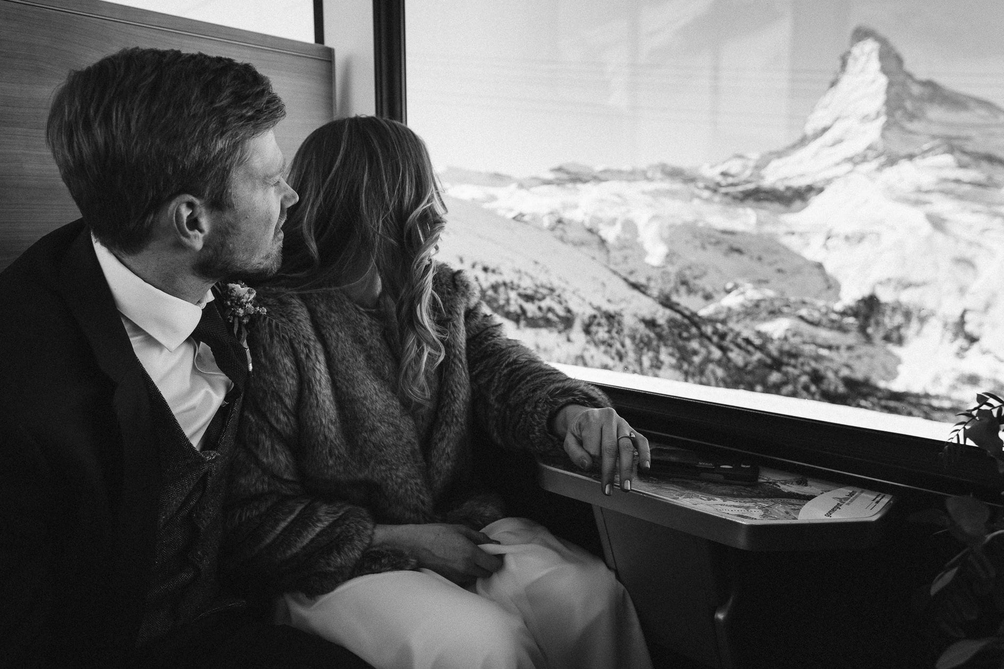 Bride and groom ride the ski train Gornergratbahn in Zermatt, Switzerland.
