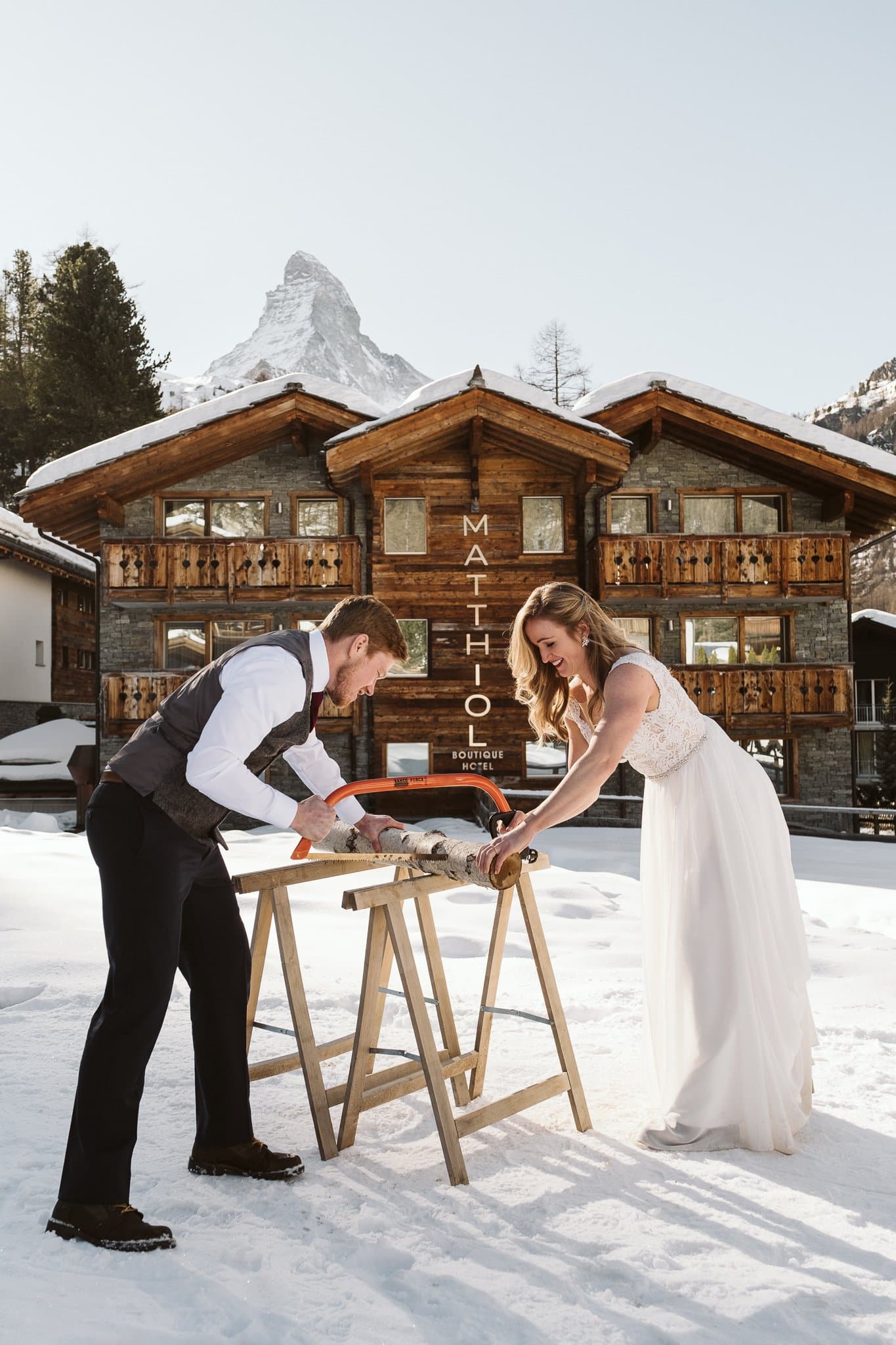 Bride and groom baumstamm sagen in front of Matthiol Boutique Hotel in Zermatt, Switzerland.