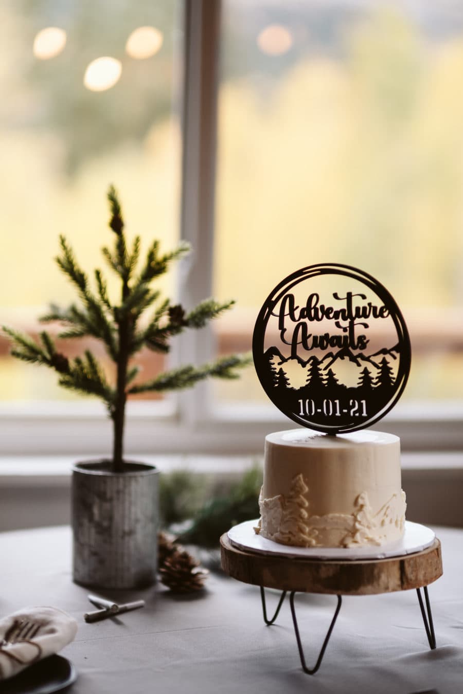 Elopement cake with "adventure awaits" cake topper