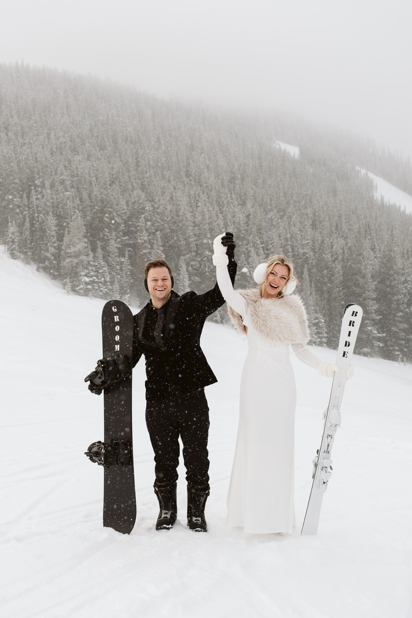Bride and groom cheer at their ski and snowboarding elopement in Colorado